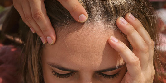Woman gently touching her hair, looking concerned.