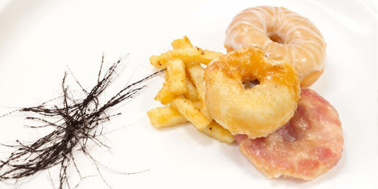 Hair strands on plate with unhealthy food