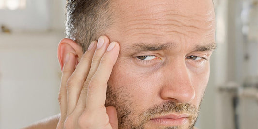 Man looking concerned, holding hair