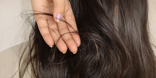 Woman touching her hair, hair strands falling.