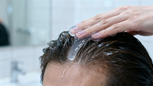 Hair gel being applied to hair on a scalp.
